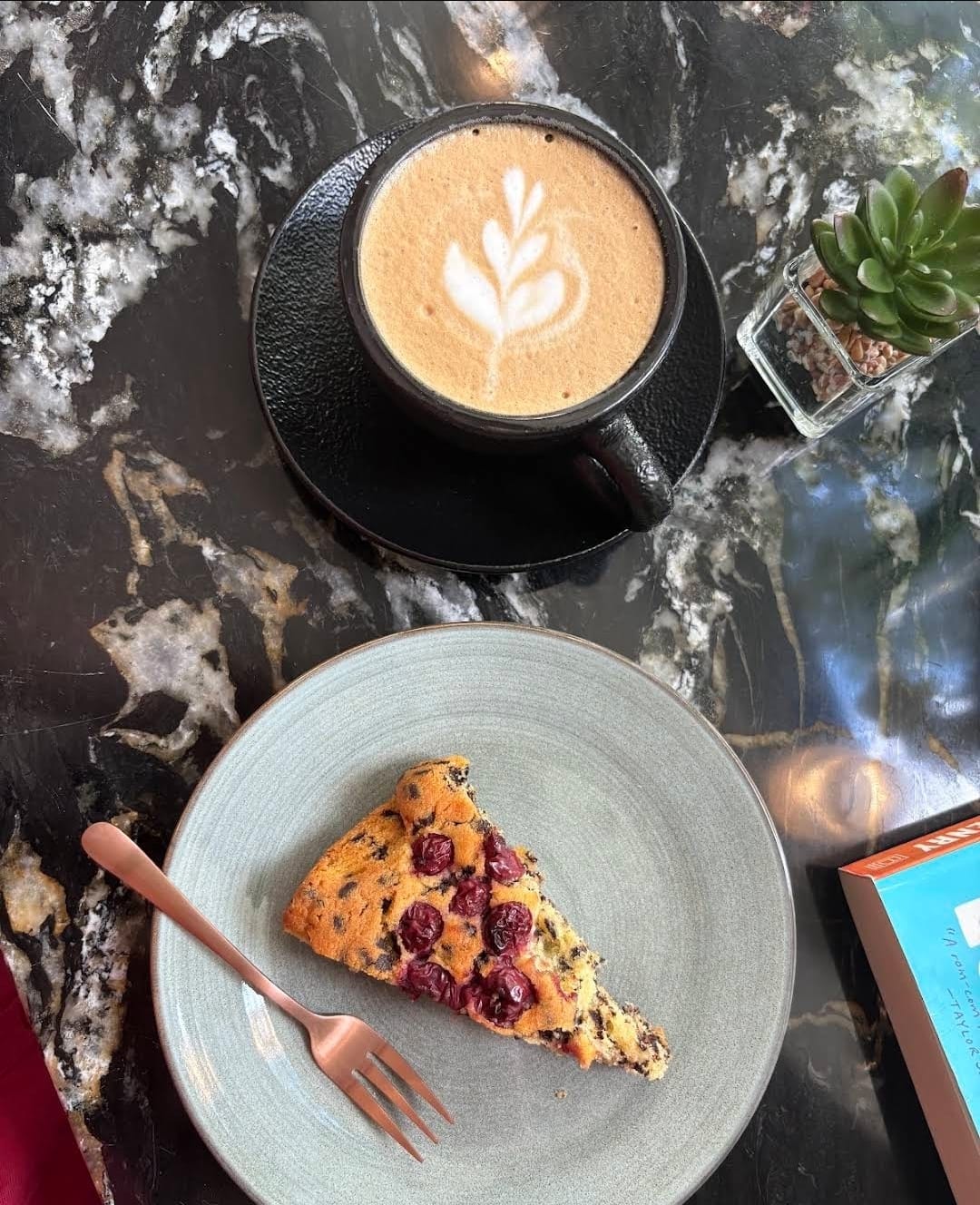Cappuccino mit einem Stück Kirschkuchen
